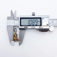 Digital caliper measuring a teddy bear charm.