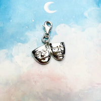 Silver comedy and tragedy mask charm.