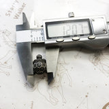 Silver turtle pendant being measured.