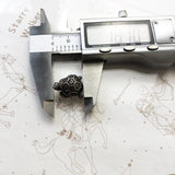 Turtle-shaped charm being measured with calipers.